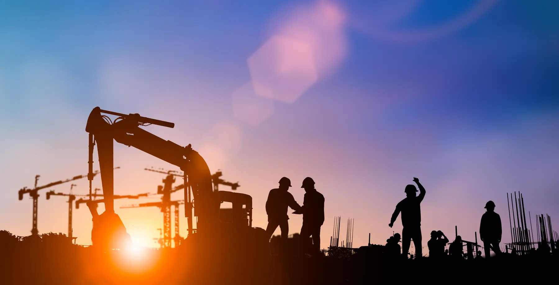 Construction crews and equipment at sunset