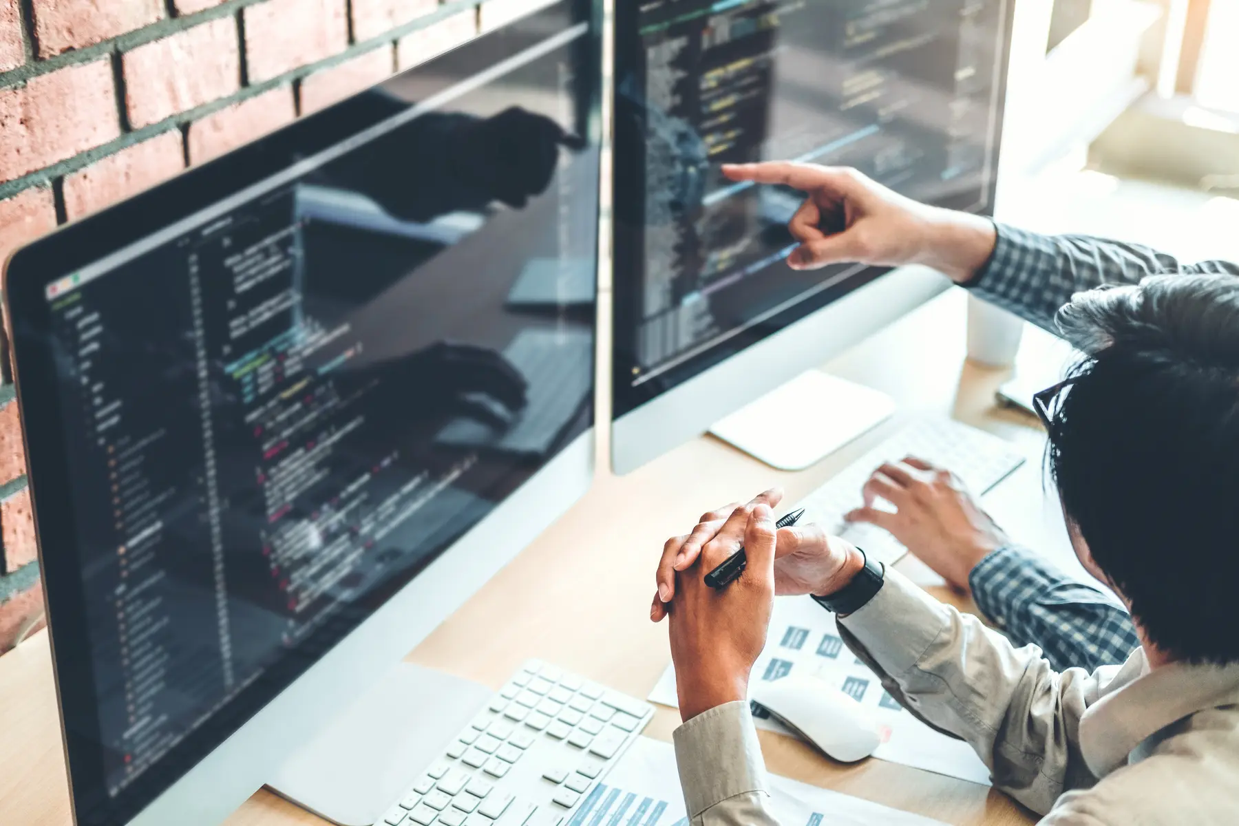Cybersecurity professionals reviewing computer code