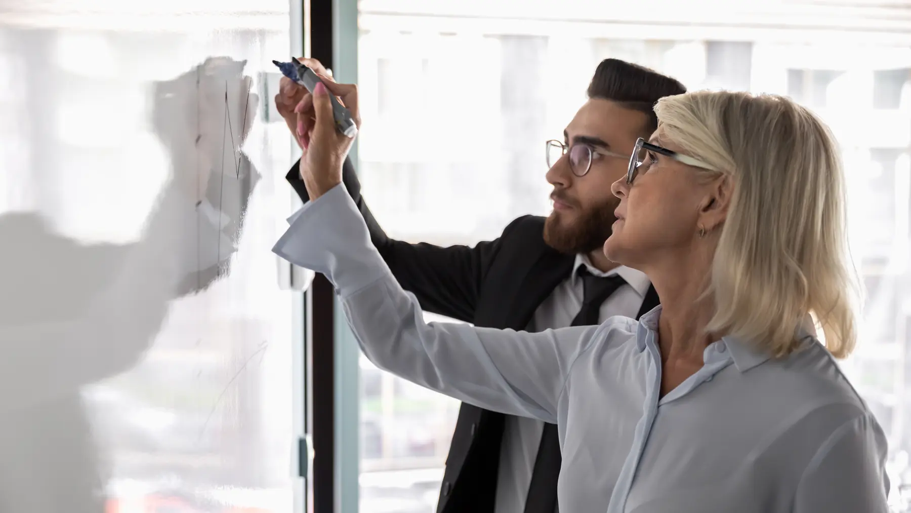 Business advisers planning strategy at a whiteboard
